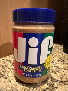 Photo of a jar of Jif peanut butter sitting on a countertop